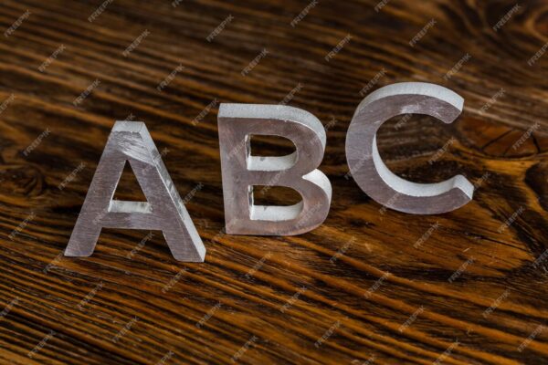 word-abc-with-white-metal-letters-standing-up-dark-brown-wood-background-with-selective-focus_636705-2665